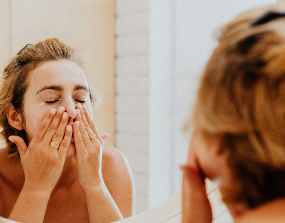 Femme nettoyant son visage lors d’une routine de soin naturelle